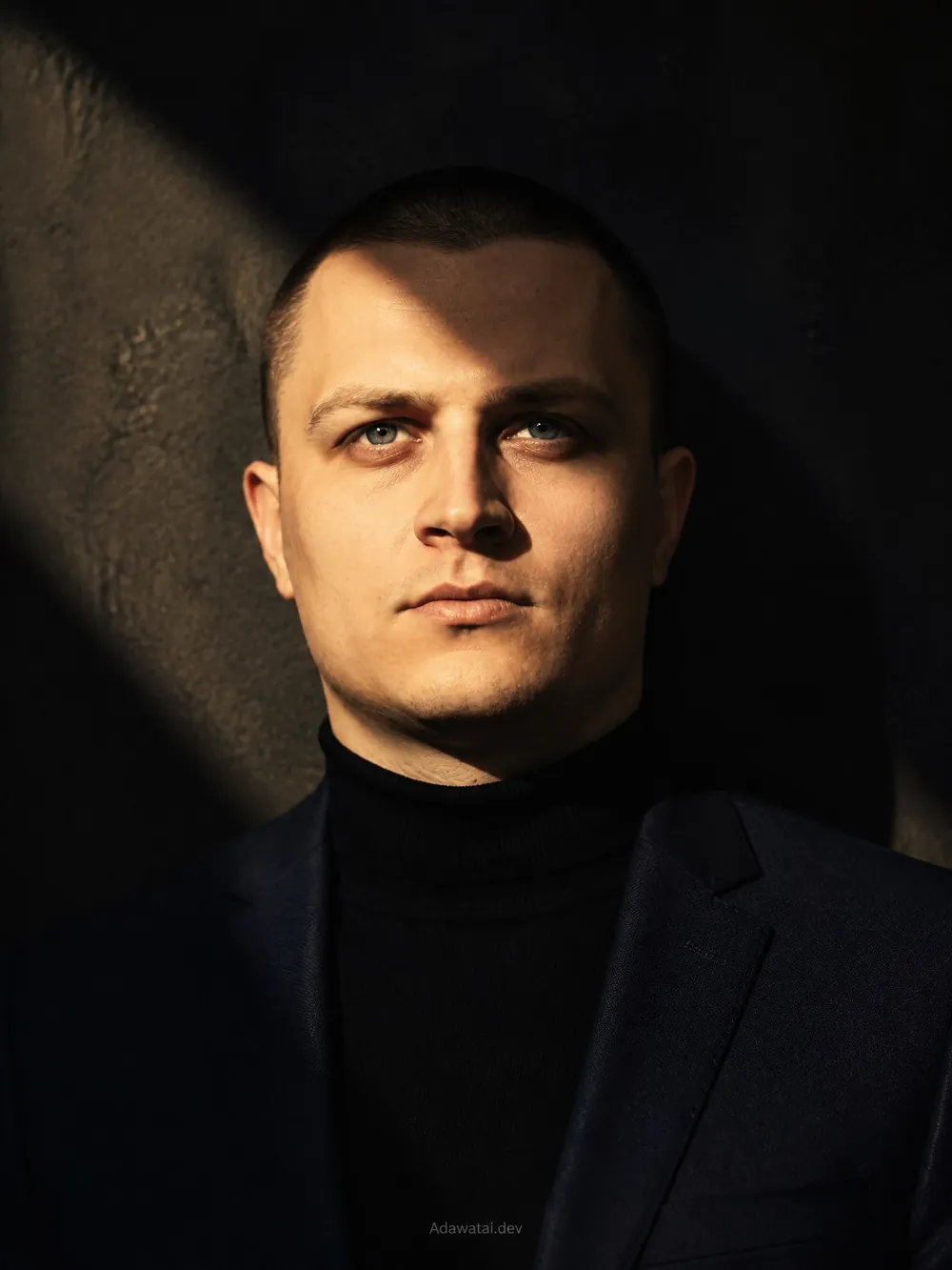 Мужчина в водолазке и пиджаке, полоса солнечного света