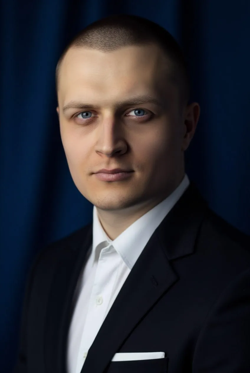 Мужчина в чёрном пиджаке на синем фоне